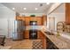 Kitchen with wood cabinets, granite countertops, stainless steel refrigerator, and wood floors at 7406 Carolina Jessamine Ct, Indian Land, SC 29707