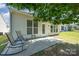 Back patio area with a couple of chairs and table, shaded by a tree at 7406 Carolina Jessamine Ct, Indian Land, SC 29707