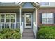 Inviting front porch with blue siding, brick accents, and a glass front door at 9214 Arbourgate Meadows Ln, Charlotte, NC 28277