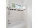 Bathroom featuring a bathtub with white tile surround and a shower head, plus a small window at 929 Blacksnake Rd, Stanley, NC 28164
