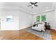 Comfortable bedroom features a ceiling fan, large windows, and hardwood floors at 929 Blacksnake Rd, Stanley, NC 28164