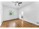 Light and airy bedroom with hardwood floors, fan, and bright window overlooking the yard at 929 Blacksnake Rd, Stanley, NC 28164