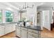 Stylish kitchen featuring white cabinets, a center island, stainless steel appliances, and hardwood floors at 929 Blacksnake Rd, Stanley, NC 28164
