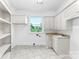 Laundry room with white cabinets, a window, and tile floors at 929 Blacksnake Rd, Stanley, NC 28164