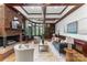 Elegant living room with brick fireplace, custom built-ins, coffered ceiling, and an abundance of natural light at 929 Blacksnake Rd, Stanley, NC 28164