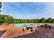 Spacious backyard swimming pool with brick patio and stone benches at 929 Blacksnake Rd, Stanley, NC 28164