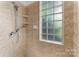 Walk-in shower boasts glass block window, hand-held shower head, and tile surround at 929 Blacksnake Rd, Stanley, NC 28164