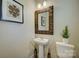 Half bathroom with pedestal sink, decorative mirror, and modern decor at 9507 Pointer Rd, Huntersville, NC 28078