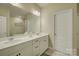Bright bathroom features dual sinks, vanity, large mirror, and modern hardware at 9507 Pointer Rd, Huntersville, NC 28078