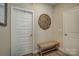 Neutral hallway with white doors, woven bench and decorative artwork at 9507 Pointer Rd, Huntersville, NC 28078