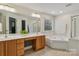 Bathroom features a dual sink vanity, tile flooring, soaking tub, and shower at 9735 Devonshire Dr, Huntersville, NC 28078