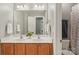 Bathroom with double sinks, wood cabinets, large mirror, and neutral paint at 9735 Devonshire Dr, Huntersville, NC 28078