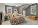 Spacious bedroom with a queen-sized bed, windows, a ceiling fan, and wood chest at 9735 Devonshire Dr, Huntersville, NC 28078