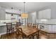 Bright dining room featuring a wooden table and chairs plus views into the modern kitchen area at 9735 Devonshire Dr, Huntersville, NC 28078