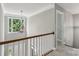 Upstairs hallway with large window and trim plus white railings and carpet at 9735 Devonshire Dr, Huntersville, NC 28078