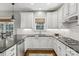 Well-lit kitchen boasts stainless steel appliances, white cabinets, and gray countertop at 9735 Devonshire Dr, Huntersville, NC 28078