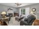Comfortable living room with a fireplace, leather seating, and a large window offering a view of the outdoors at 9735 Devonshire Dr, Huntersville, NC 28078