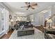 Open living room with hardwood floors, a ceiling fan, and a view of the kitchen and staircase at 9735 Devonshire Dr, Huntersville, NC 28078
