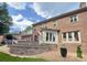 Back exterior brick home with a well-kept yard, featuring a tiered stone patio at 10500 Kilmory Ter, Charlotte, NC 28210