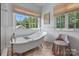 Bright bathroom with wainscoting, a soaking tub, and large windows at 10500 Kilmory Ter, Charlotte, NC 28210