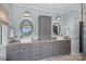 Bathroom featuring double sinks, granite countertops, and grey cabinetry at 10500 Kilmory Ter, Charlotte, NC 28210