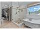 Bathroom featuring tiled shower, soaking tub, and lots of natural light at 10500 Kilmory Ter, Charlotte, NC 28210