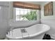 Bright bathroom features a soaking tub and window at 10500 Kilmory Ter, Charlotte, NC 28210