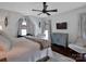 Cozy bedroom with a ceiling fan, TV, hardwood floors and large windows at 10500 Kilmory Ter, Charlotte, NC 28210