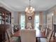 Elegant dining room featuring a chandelier, hardwood floors, and natural light from large windows at 10500 Kilmory Ter, Charlotte, NC 28210