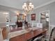 Spacious dining room with hardwood floors, chandelier, wainscoting, and elegant decor at 10500 Kilmory Ter, Charlotte, NC 28210