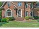 Close up of the brick front of this home, showing the front door and surrounding landscaping at 10500 Kilmory Ter, Charlotte, NC 28210