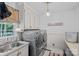 Bright laundry room with sink, modern washer and dryer, overhead cabinets, and light fixtures at 10500 Kilmory Ter, Charlotte, NC 28210