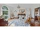 Elegant living room with floral rug, vintage furniture, and large arched window providing natural light at 10500 Kilmory Ter, Charlotte, NC 28210