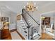Classic staircase design featuring patterned carpet, dark railing, white risers and balusters and chandelier lighting at 10500 Kilmory Ter, Charlotte, NC 28210