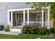 Covered porch with string lights and seating area, surrounded by lush greenery and landscaping at 15628 Waterfront Dr, Huntersville, NC 28078