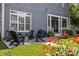 Backyard patio with outdoor seating and colorful flowers, backed by a well-maintained lawn at 15628 Waterfront Dr, Huntersville, NC 28078