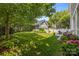 Backyard with a patio, green lawn, mature tree, and colorful flowers at 15628 Waterfront Dr, Huntersville, NC 28078