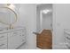 Elegant bathroom with white vanity, brushed gold fixtures, and a view into a hallway at 15628 Waterfront Dr, Huntersville, NC 28078