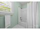 Bright bathroom features a tub with shower and a mint colored wall at 15628 Waterfront Dr, Huntersville, NC 28078