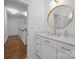 Stylish bathroom featuring white vanity, elegant gold fixtures, and a decorative oval mirror at 15628 Waterfront Dr, Huntersville, NC 28078