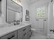 Well-lit bathroom with gray vanity, marble countertop, and modern black fixtures at 15628 Waterfront Dr, Huntersville, NC 28078