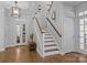 Inviting foyer with hardwood floors, staircase, and modern light fixture creates a welcoming entrance at 15628 Waterfront Dr, Huntersville, NC 28078
