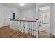 Second floor hallway with hardwood floors and white trim, offering a view of a sunlit bedroom at 15628 Waterfront Dr, Huntersville, NC 28078