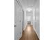 Upstairs hallway with hardwood floors, white trim, and access to a laundry area at 15628 Waterfront Dr, Huntersville, NC 28078