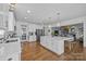 Expansive open kitchen with white cabinets, a large central island, stainless steel appliances, and modern lighting at 15628 Waterfront Dr, Huntersville, NC 28078