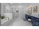 Elegant bathroom with walk-in shower, soaking tub, and vanity with navy cabinets at 15628 Waterfront Dr, Huntersville, NC 28078