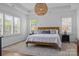Bright main bedroom featuring hardwood floors, a large bed, and tray ceiling with stylish light fixture at 15628 Waterfront Dr, Huntersville, NC 28078