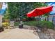 Backyard patio with a fire pit, table, chairs, and a vibrant red umbrella at 1668 Tate Rd, Rock Hill, SC 29732