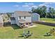 A well-maintained yard boasting a covered patio, outdoor dining, a fire pit, and space for recreation at 210 Clove Hitch Dr, Statesville, NC 28677