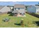 Expansive backyard featuring a covered patio, outdoor seating, fire pit, and play set on a lush lawn at 210 Clove Hitch Dr, Statesville, NC 28677